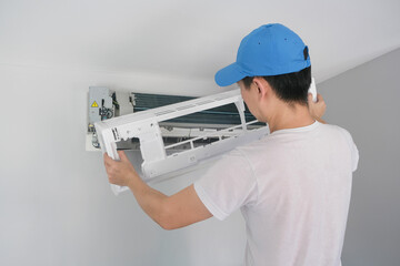 Male repair air conditioner at room, He is air technician , mechanic , engineer. Maintenance air conditioner myself.