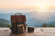 Travel backpack and retro camera with landscape view of mountain at sunrise