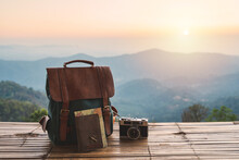 Travel Backpack And Retro Camera With Landscape View Of Mountain At Sunrise
