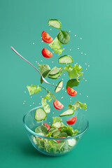 green salad falling into a plate on a green background