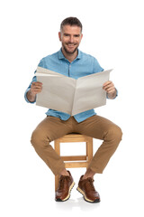 Wall Mural - happy middle aged man reading newspaper and smiling