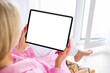 © Kaspars Grinvalds - Woman using tablet computer at home, empty white screen mockup