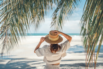 summer beach vacation concept, happy woman with hat relaxing at the seaside and looking away, in the