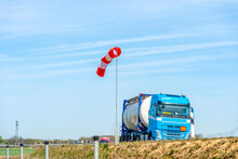 Blue Fuel Truck On Motorway In Front Of Windsock