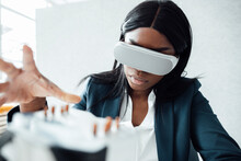 Businesswoman Wearing Virtual Reality Simulator Gesturing At Cooling Module In Office