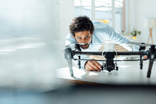 Businessman Analyzing Drone At Desk In Office
