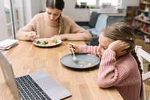 Sad Young Woman And Bored Girl Eating At Home Watching Laptop