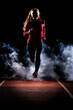 © Westend61 - Young woman jogging on running track amidst fog in dark at night