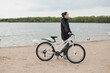 © paralisart - A young woman with a bicycle on the lake
