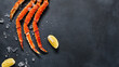 © Ryzhkov - Crab legs top view on dark background. Delicatessen crab seafood on black slate table. Crustacean seafood aesthetics. Luxury crab meat food flat lay. Seafood menu background with alaskan crab legs.