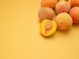 Wall Mural - Pile of fresh peaches fruit over a yellow background