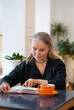 © Анжелла Антоновская - Beautiful elderly woman drinking tea in a cafe and reading a book