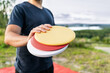 Disc golf player with frisbee equipment in park course. Man playing discgolf. Outdoor sport tournament. Summer landscape in Finland.