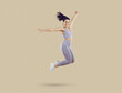 Happy excited cheerful joyful beautiful fit young woman in lilac crop top and leggings smiling and jumping against beige studio background. Sport, fitness, workout, energy, healthy lifestyle concept