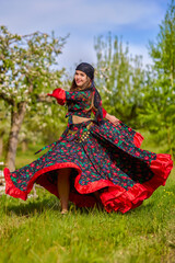 Wall Mural - beautiful woman in traditional gypsy dress posing in nature in spring