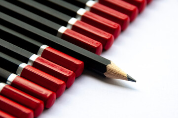 one pencil standing out from the group of other pencil. leadership concept.