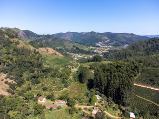 valley with mountains, coffee plantation and eucalyptus in beautiful green - aerial drone view - city from the interior