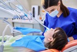 Fototapeta Panele - Doctor dentist treats teeth to a young teenage female patient