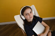 © ADDICTIVE STOCK - Tranquil girl sitting on chair and listening to song