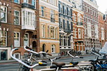 City Street With Aged Brick Buildings And Bikes Parked At Roadside