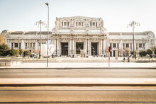 MILAN, ITALY - APRIL 12, 2022: Milan Central Train Station Building (Stazione Centrale) With People In Front Of The Entrance In The Early Morning In Milan, Italy.