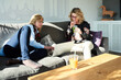 © SteelStock - Blonde women on sofa with laptop and drinks.