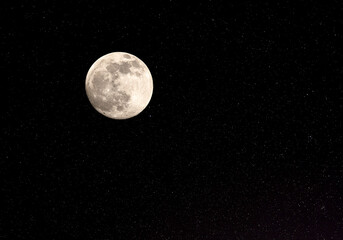 full moon and stars against a black night sky.
