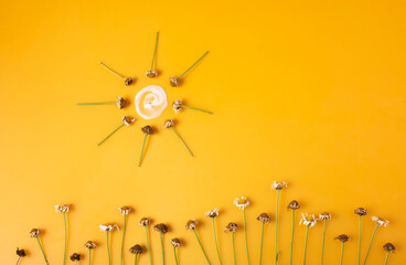 Llegó el verano y nos hemos de protejer del sol con crema solar. 
Fotografía conceptual sobre fondo naranja de fotos marchitas y dibujo de sol con crema solar