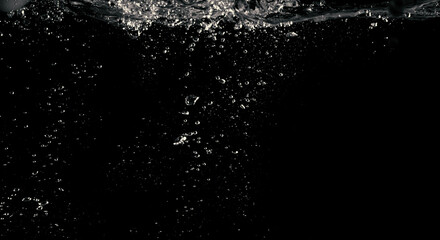 Wall Mural - Blurry images of clear transperant soda liquid bubbles splashing or sparkling and moving up in black background for represent the refreshing moments after drink carbonated water.