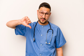 Wall Mural - Hispanic nurse man isolated on white background showing a dislike gesture, thumbs down. Disagreement concept.