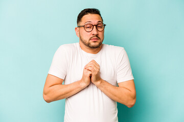 Wall Mural - Young hispanic man isolated on blue background scared and afraid.