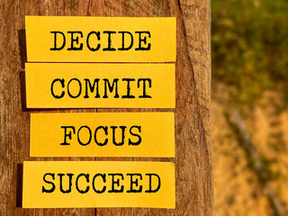 Wall Mural - Inspirational and Motivational Concept - DECIDE COMMIT FOCUS SUCCEED text on notepaper background. Stock photo.