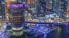 Dubai Marina Waterfront And Building With Different Restaurants At Each Floor Aerial Night Timelapse.