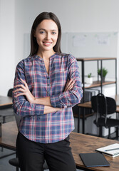 Wall Mural - Smiling young businesswoman office portrait, Self confident young woman with crossed hands in office, People, candid portraits, business, lifestyle concept