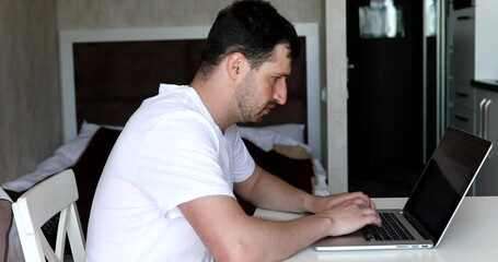 Poster - Young Man Freelancer Using Laptop, Typing, Scrolling, Surfing Web, Looking at the Screen.