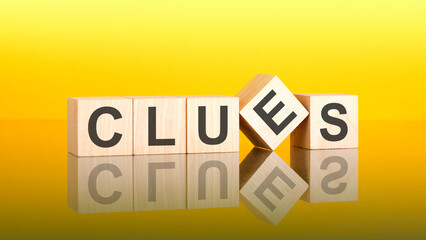 Poster - clues - text of on wooden cubes, reflected from the bright yellow surface