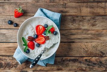 Poster - Milk rice porridge with blueberries and strawberries.