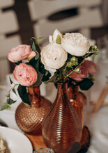Decor And Floristry Of The Festive Table In The Restaurant. A Bouquet Of Eucalyptus And Ficus Leaves, Pink Berries, White Roses And Carnations Stands In A Transparent Glass Jar. Wedding, Holiday.