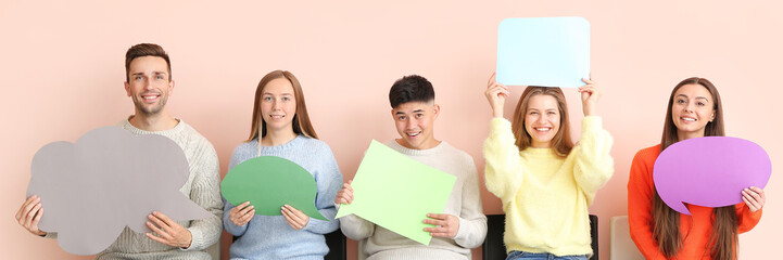 Wall Mural - Group of young people with blank speech bubbles on light color background