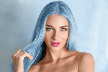 Wall Mural - Beautiful young woman with blue hair on light color background