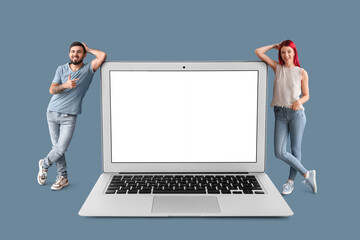 Canvas Print - Happy young couple and big laptop with blank screen on blue background