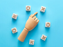 Wooden Hand And Cubes For Tic-tac-toe Game On Blue Background