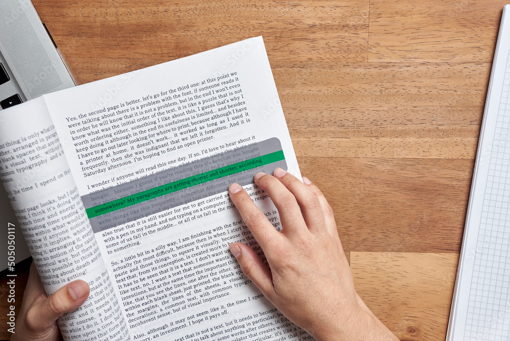Student with dyslexia reading a book with the help of a coloured ...