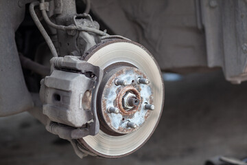 Poster - Disc brake of the vehicle for repair, in process of new tire replacement. Car brake repairing in garage.Suspension of car for maintenance brakes and shock absorber systems. Replacement of brake pads.