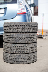 Poster - 4 new tires that change tires in the auto repair service center, blurred background, the background is a new car in the stock blur for the industry, a four-wheeled tire set at a large warehouse