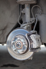 Poster - Disc brake of the vehicle for repair, in process of new tire replacement. Car brake repairing in garage.Suspension of car for maintenance brakes and shock absorber systems. Replacement of brake pads.