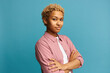 Confident successful attractive blonde African American business woman posing against blue background with copy space for your content in pink casual clothes. Motivation and success concept