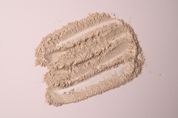 Loose cosmetic powder textured nude beige background. Make up surface. Background of cosmetic products strokes