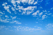Summer sky. White clouds in the blue sky. Heaven and infinity. Beautiful bright blue background. Light cloudy, good weather. Curly clouds on a sunny day