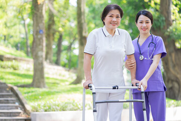 Asian female nurse taking care of a middle-aged female patient in the park